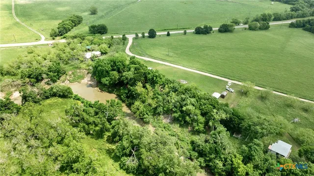 a view of a green field with lots of bushes
