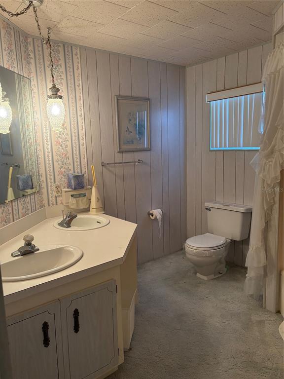 10057 110th Place, Unit 243 Largo, FL 33773 - Photo 20 of 32 a bathroom with a sink a toilet and mirror