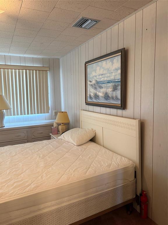 10057 110th Place, Unit 243 Largo, FL 33773 - Photo 22 of 32 a bedroom with a bed and a painting on the wall