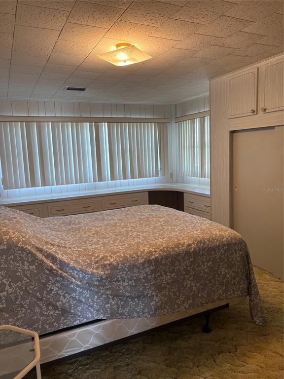 10057 110th Place, Unit 243 Largo, FL 33773 - Photo 24 of 32 a bed sitting in a bedroom next to a window
