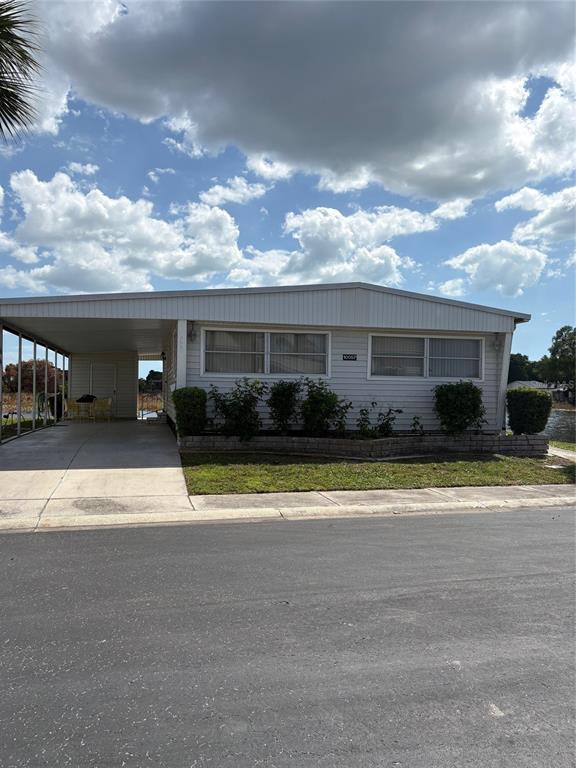 10057 110th Place, Unit 243 Largo, FL 33773 - Photo 5 of 32 a view of yellow house with a large trees next to a yard