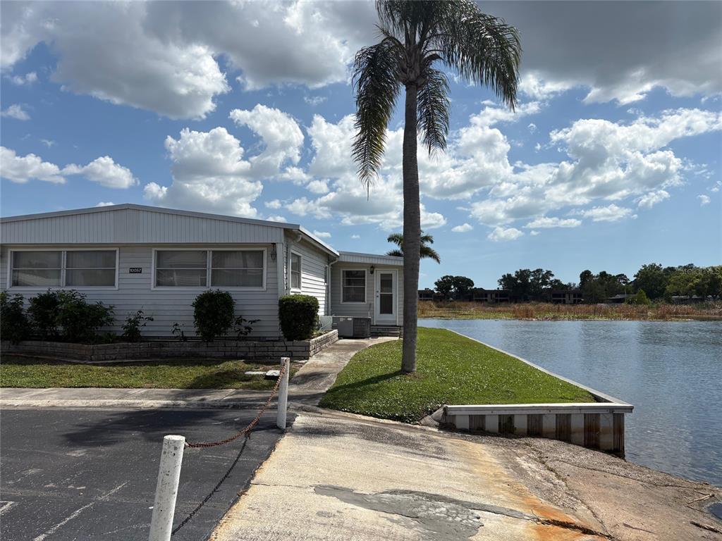 10057 110th Place, Unit 243 Largo, FL 33773 - Photo 6 of 32 a front view of a house with garden and swimming pool