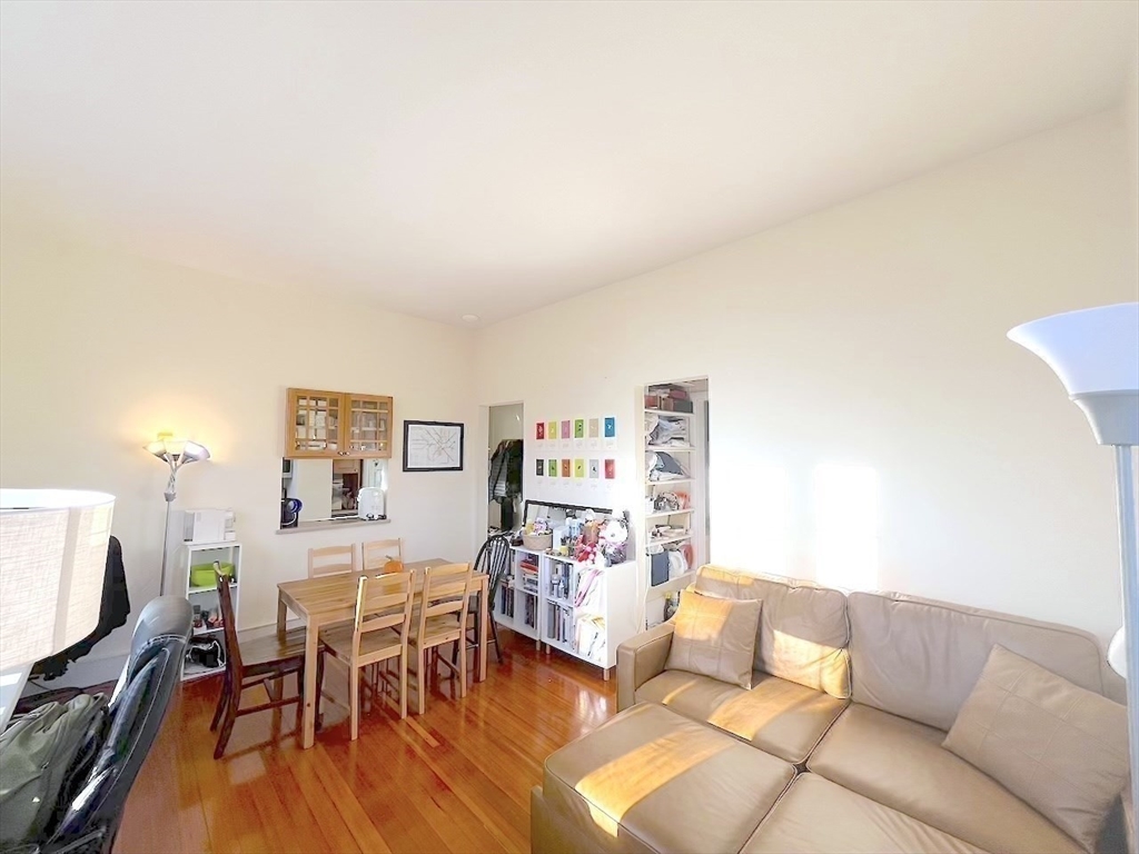 371 Harvard Street, Unit 3C Cambridge, MA 02138 - Photo 11 of 27 a living room with furniture and a wooden floor