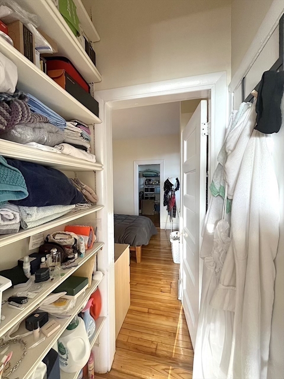 371 Harvard Street, Unit 3C Cambridge, MA 02138 - Photo 16 of 27 a hallway with lots of different colored cloths