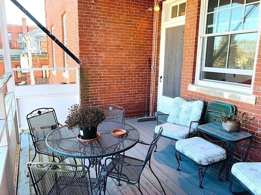 371 Harvard Street, Unit 3C Cambridge, MA 02138 - Photo 25 of 27 a view of a outdoor seating area with furniture and wooden floor