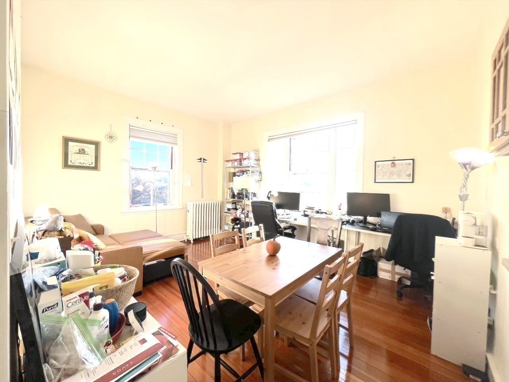 371 Harvard Street, Unit 3C Cambridge, MA 02138 - Photo 10 of 27 a view of a dining room with furniture window and wooden floor