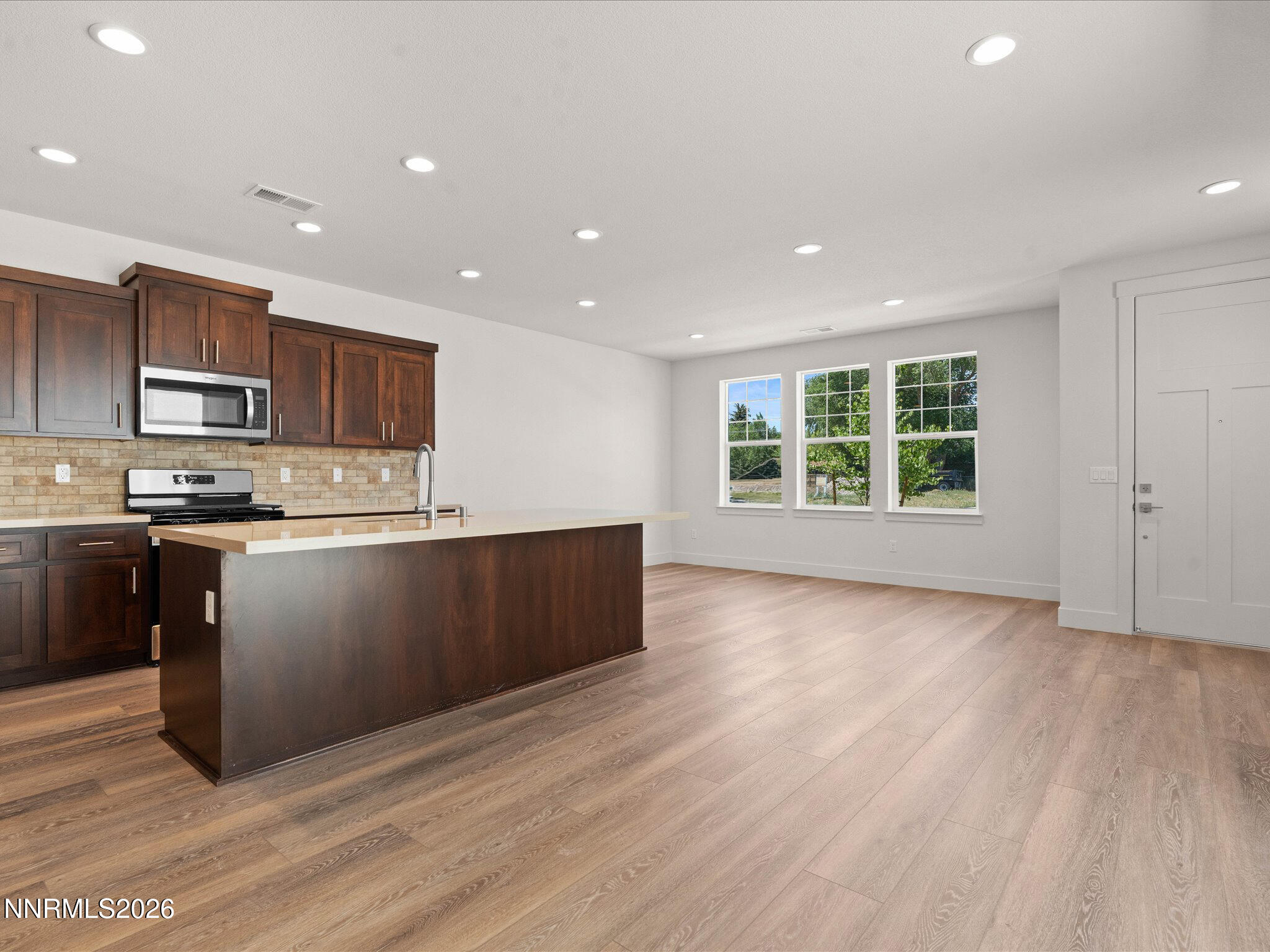 1371 Vine Gate Road, Unit HOMESITE 49 Carson City, NV 89701 - Photo 5 of 24 a kitchen with stainless steel appliances granite countertop a refrigerator a sink a stove a microwave and island with wooden floors