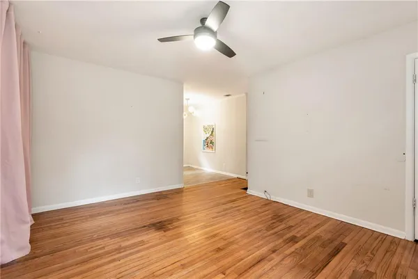a view of an empty room with wooden floor