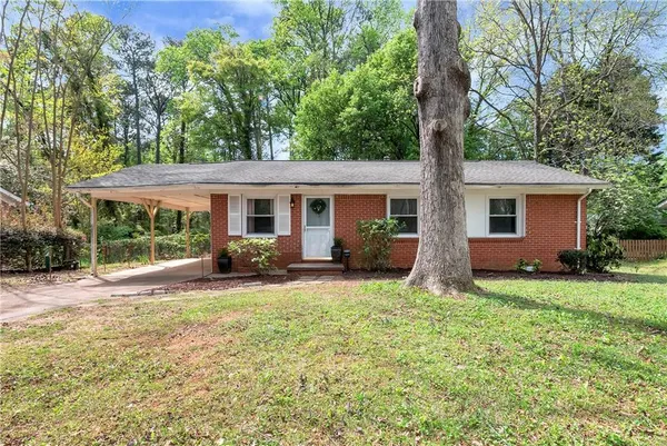 a view of a house with backyard and a tree