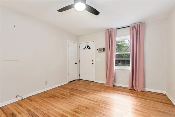 a view of a livingroom with wooden floor and a ceiling fan