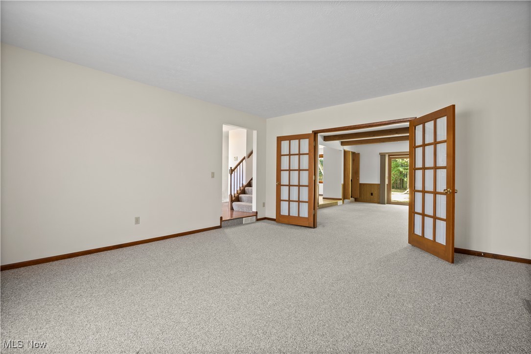 1711 Gulf Road Elyria, OH 44035 - Photo 10 of 50 Unfurnished room featuring french doors, stairs, and light carpet