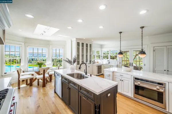 a kitchen with stainless steel appliances granite countertop a stove a sink and a wooden floors