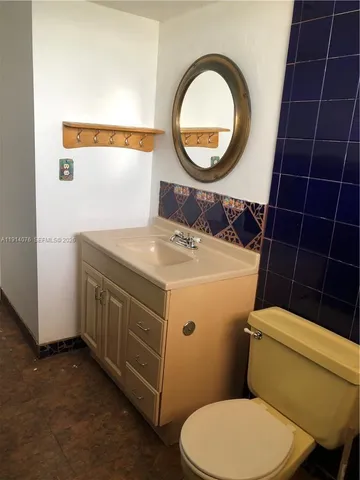 a bathroom with a toilet a sink and a mirror