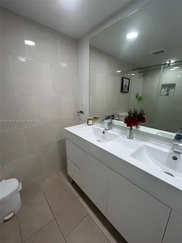 a bathroom with a sink a toilet and a mirror