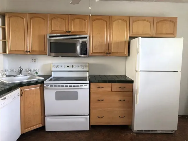 a kitchen with granite countertop cabinets and appliances