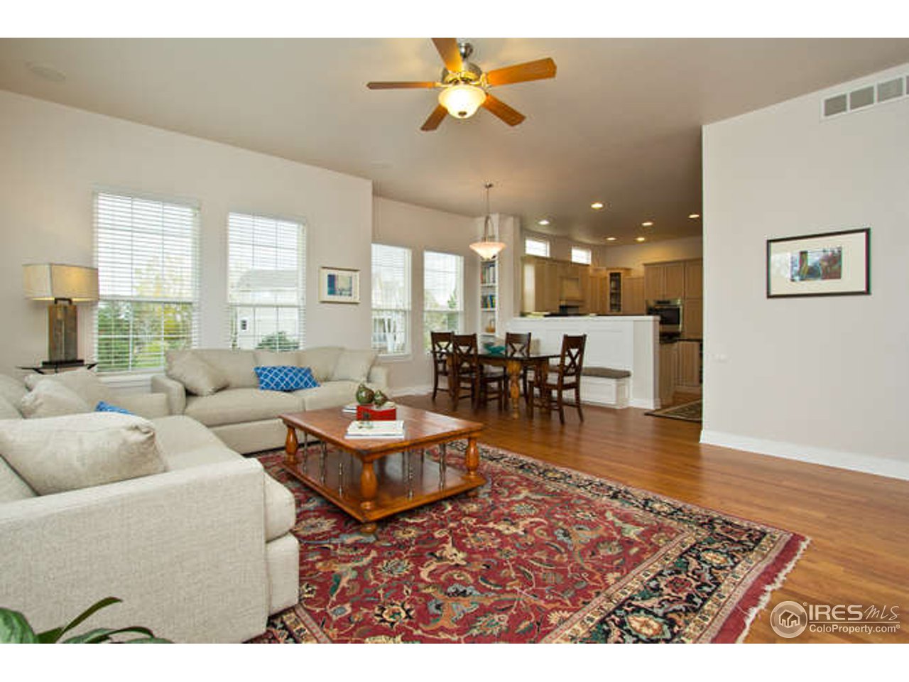 3460 Rookery Road Fort Collins, CO 80528 - Photo 12 of 23 a living room with furniture and a dining table with wooden floor