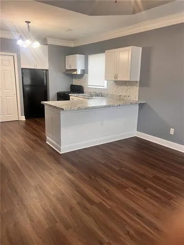 a view of kitchen with granite countertop cabinets and refrigerator