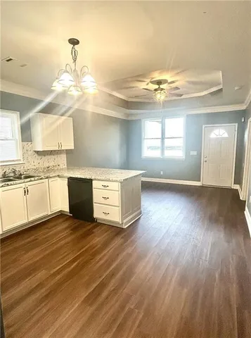 a view of a kitchen with kitchen island a sink wooden floor and a counter top space