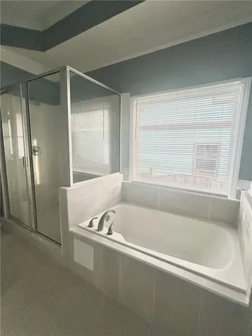 a white bath tub sitting in a bathroom next to a window