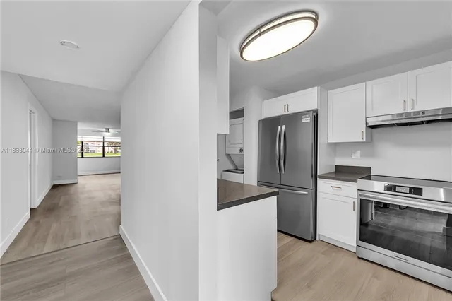 a kitchen with stainless steel appliances granite countertop a refrigerator a stove and a sink