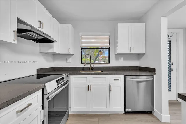 a kitchen with stainless steel appliances granite countertop a sink a stove and a microwave