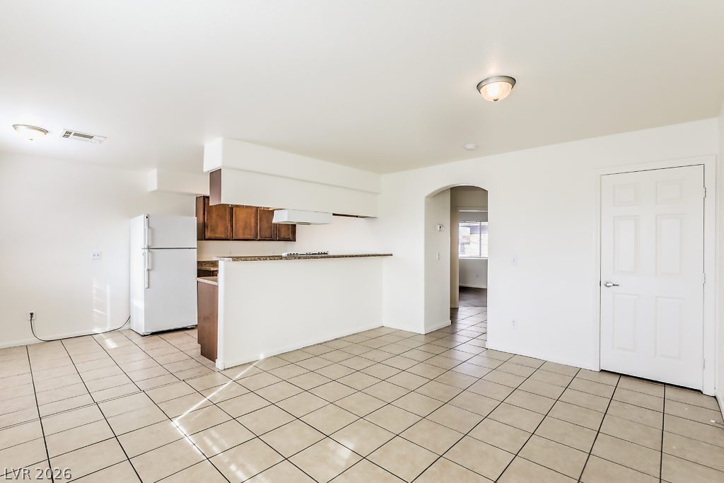 3127 North Walnut Road, Unit A Las Vegas, NV 89115 - Photo 9 of 12 A well-lit kitchen with a breakfast bar seamlessly connects to a spacious living area.