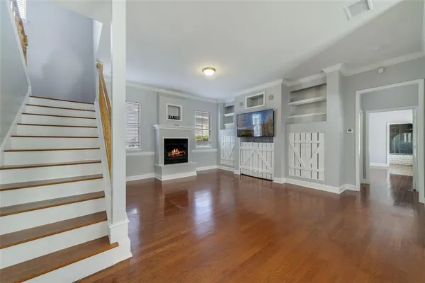 a view of a livingroom with wooden floor and a fireplace