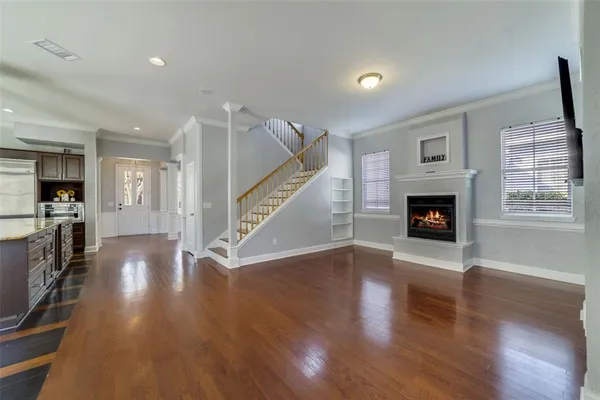 a view of a livingroom with wooden floor and a fireplace