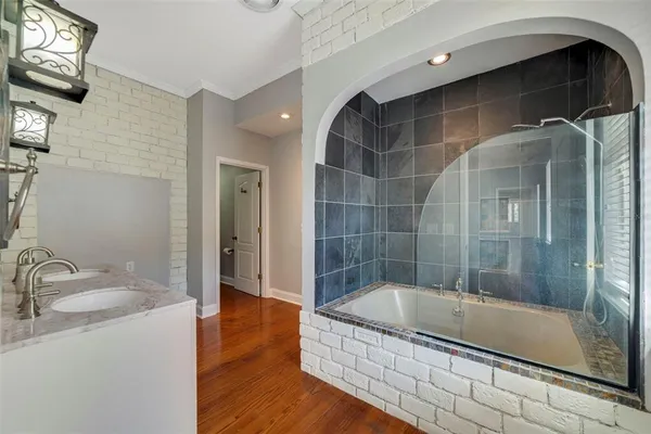 a bathroom with a granite countertop bathtub shower sink and mirror