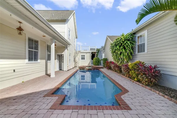 a view of a house with pool and sitting area