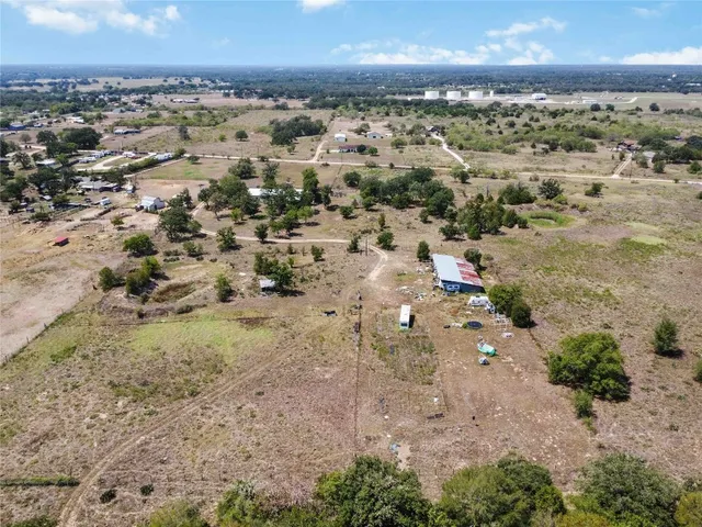 an aerial view of a house with a yard and a lot of flower plants