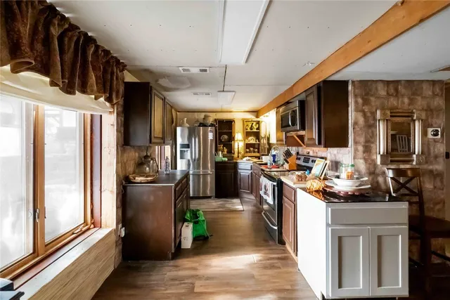 a view of a kitchen with stainless steel appliances granite countertop a refrigerator and a sink