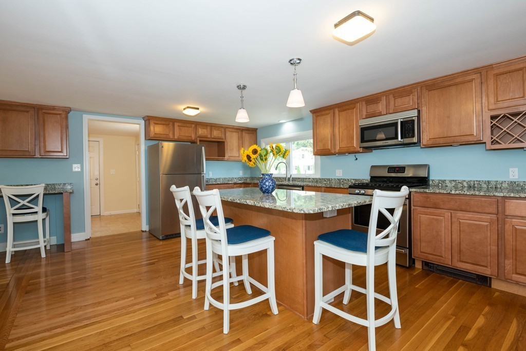 27 Margaret Road Hamilton, MA 01982 - Photo 5 of 30 a kitchen with stainless steel appliances granite countertop a table and chairs in it