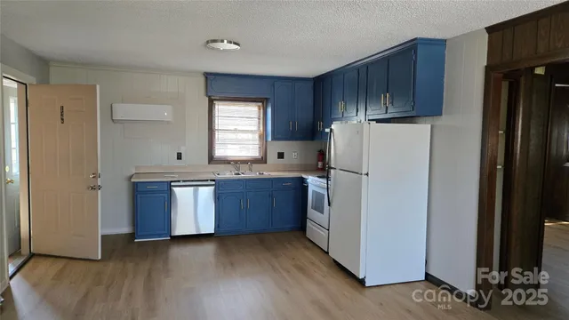 a kitchen with sink a refrigerator and wooden cabinets