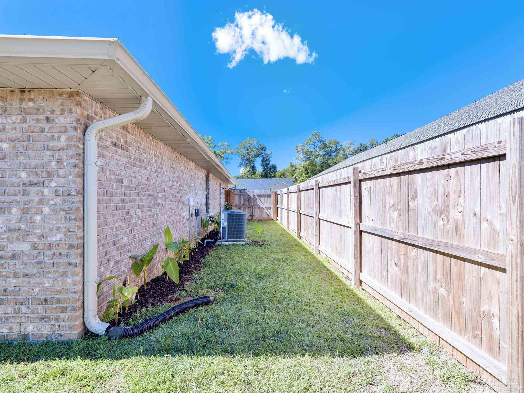 5956 Parsonage Circle Milton, FL 32570 - Photo 13 of 66 a view of a backyard with plants and a fountain