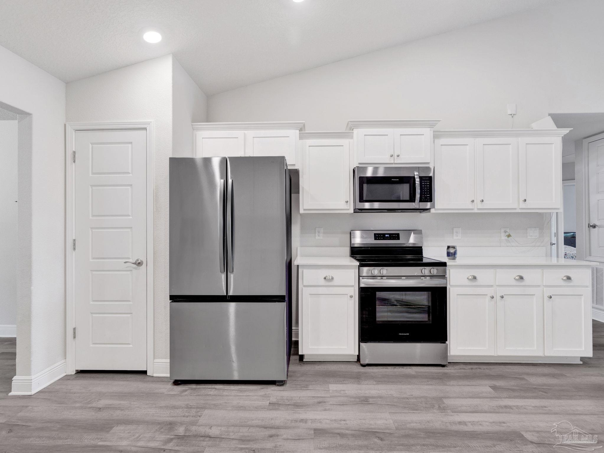 5956 Parsonage Circle Milton, FL 32570 - Photo 28 of 66 a kitchen with a refrigerator stove and white cabinets
