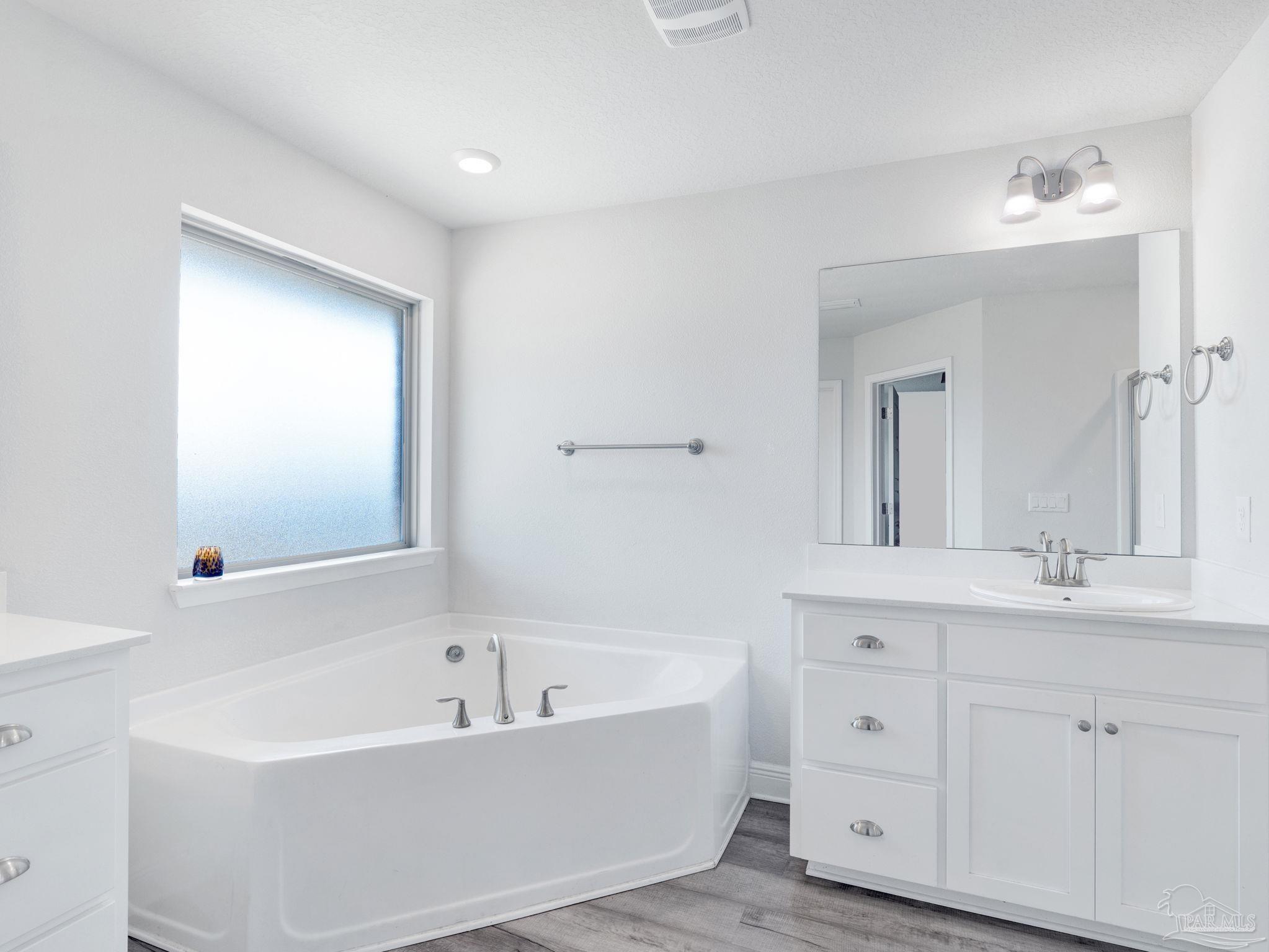 5956 Parsonage Circle Milton, FL 32570 - Photo 53 of 66 a bathroom with a bathtub a mirror a sink and vanity