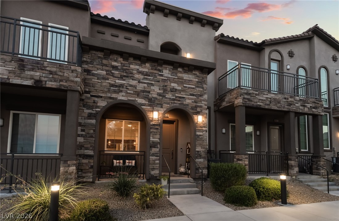 6432 Spring Jog Street Las Vegas, NV 89166 - Photo 47 of 61 The striking stone facade and arched entryways define this modern townhome's curb appeal.