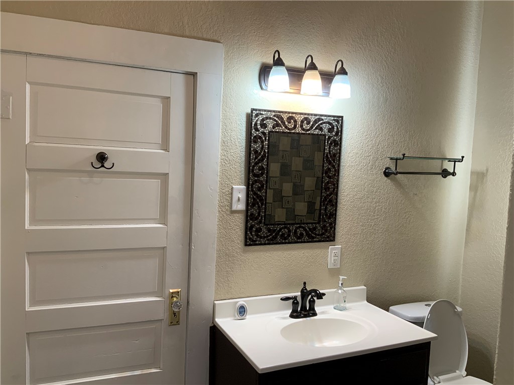 207 North Archer Street Groesbeck, TX 76642 - Photo 11 of 25 a bathroom with a sink and a mirror