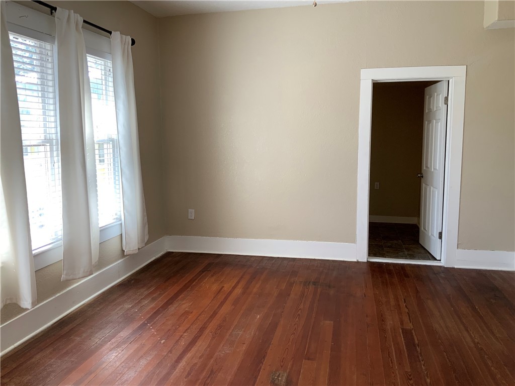 207 North Archer Street Groesbeck, TX 76642 - Photo 13 of 25 an empty room with wooden floor and windows