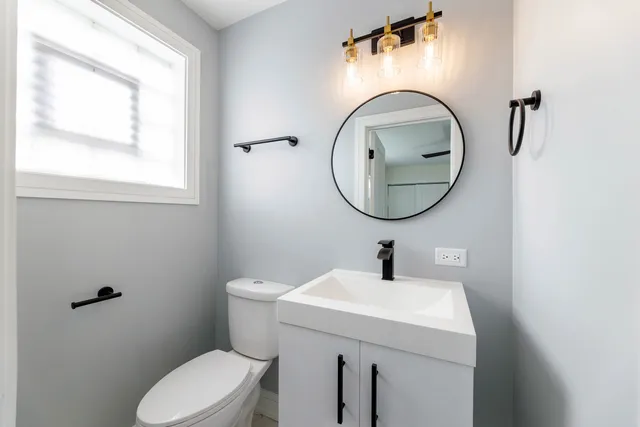 a bathroom with a toilet sink and mirror