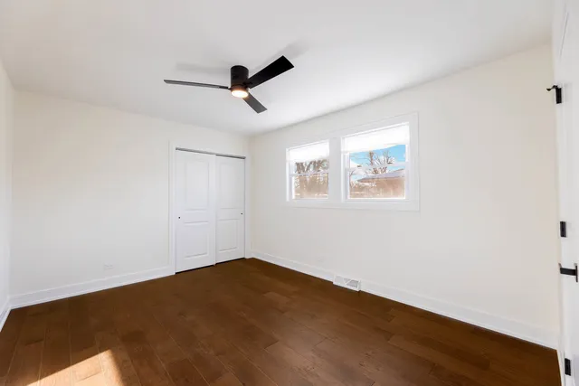 a view of a big room with wooden floor and windows in a room