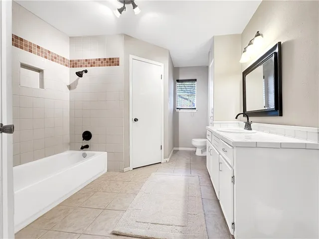 a bathroom with a double vanity sink a mirror and a bathtub