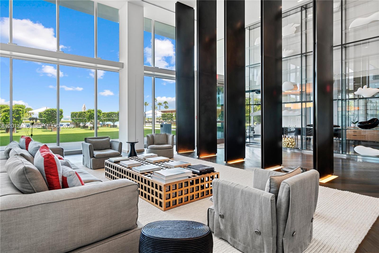 360 Ocean Drive, Unit 1106S Key Biscayne, FL 33149 - Photo 31 of 67 Lobby Lounge – A dramatic double-height lounge showcases floor-to-ceiling windows, sculptural black columns, and refined seating areas. The open design frames garden and ocean views while creating an impressive arrival experience.