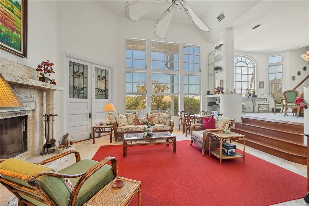 1660 16th Street East Boca Grande, FL 33921 - Photo 21 of 54 a living room with furniture a fireplace and large windows