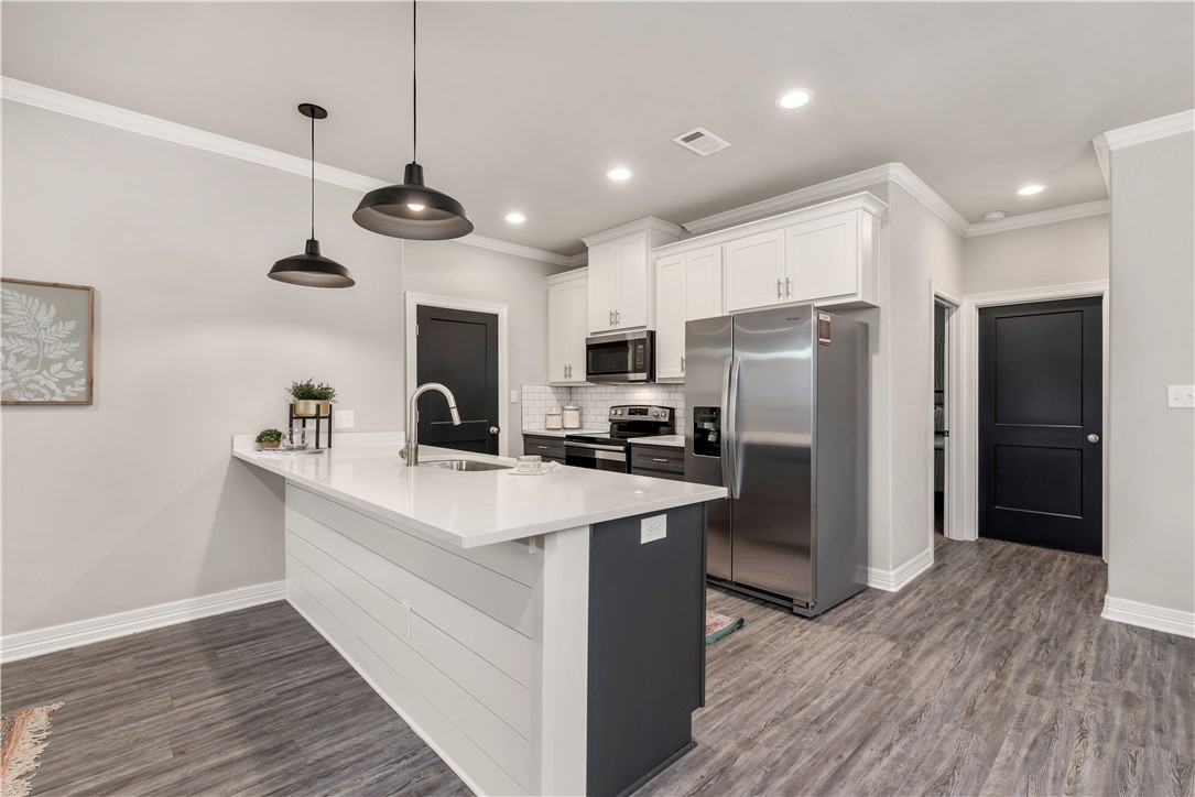705 Turner Street College Station, TX 77840 - Photo 7 of 19 a kitchen with a refrigerator a sink and wooden floor