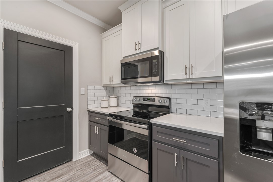 705 Turner Street College Station, TX 77840 - Photo 8 of 19 a kitchen with cabinets stainless steel appliances and wooden floor