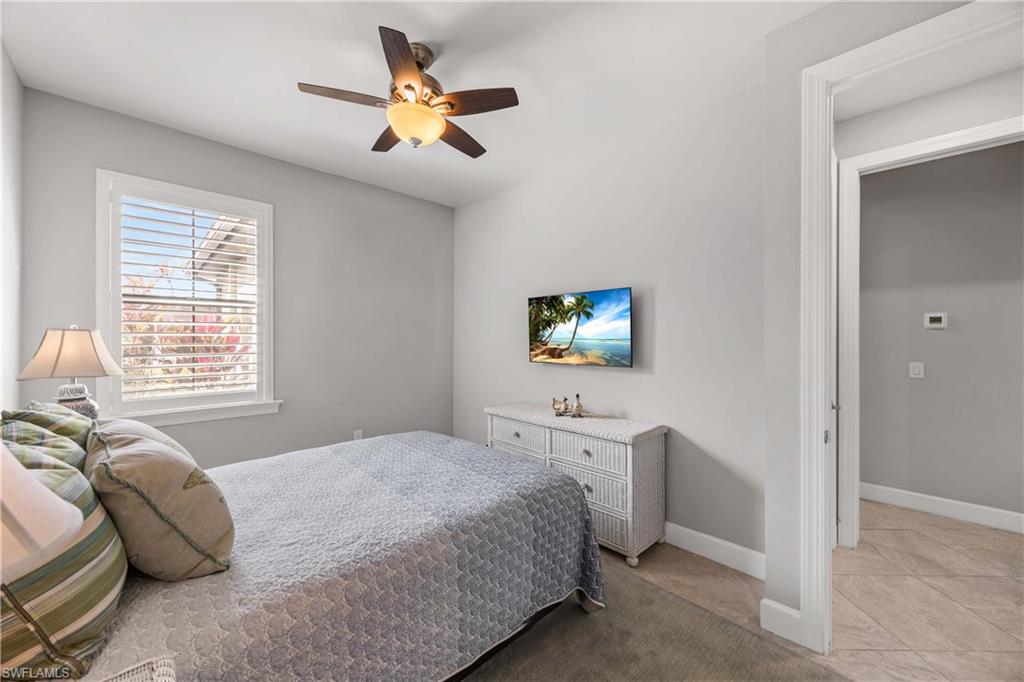 7658 Jacaranda Lane Naples, FL 34114 - Photo 14 of 30 Bedroom featuring a ceiling fan natural light, tile flooring, walk in closet