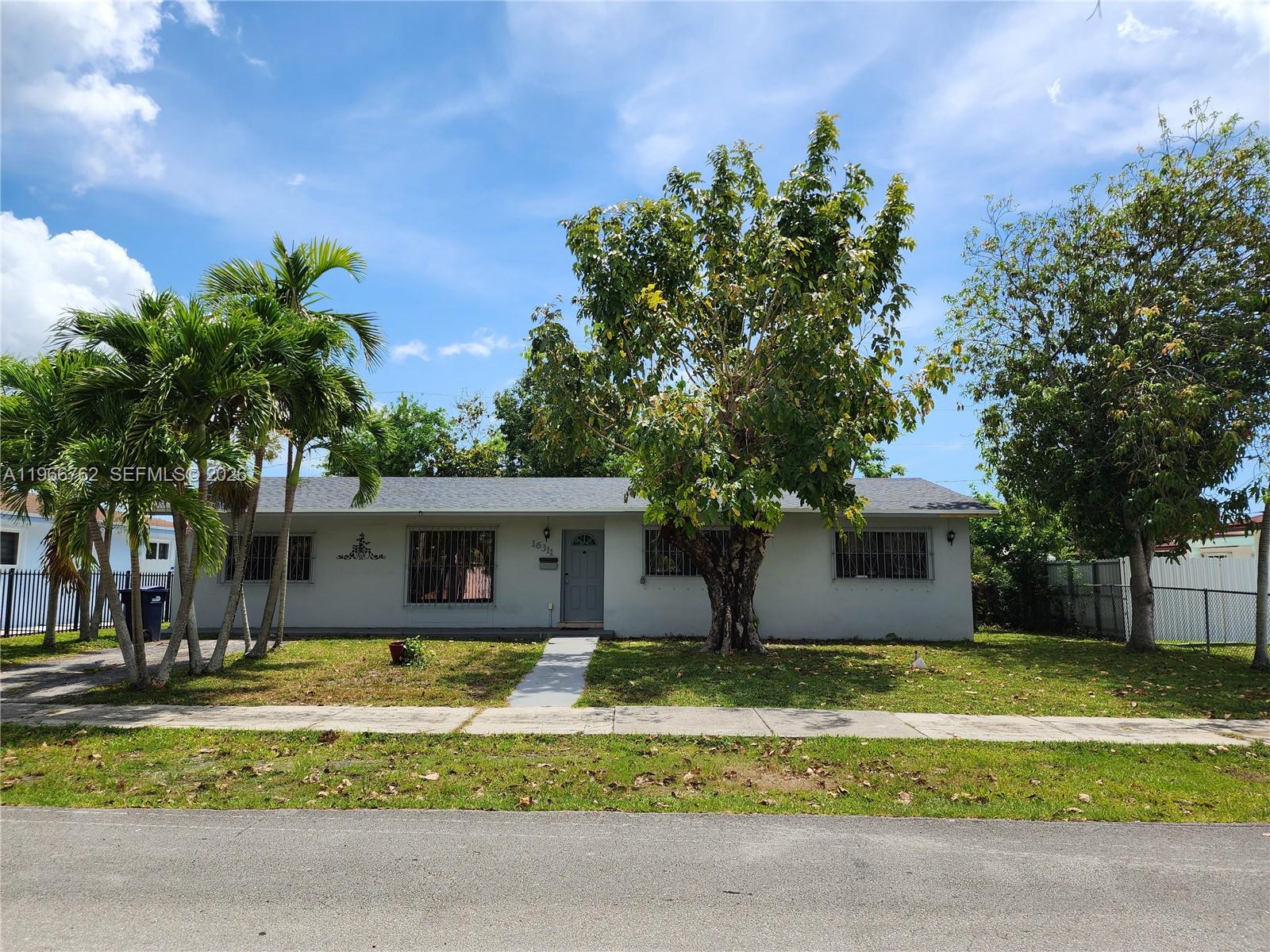 16311 Southwest 102nd Place, Unit A Miami, FL 33157 - Photo 1 of 15 a front view of a house with a garden