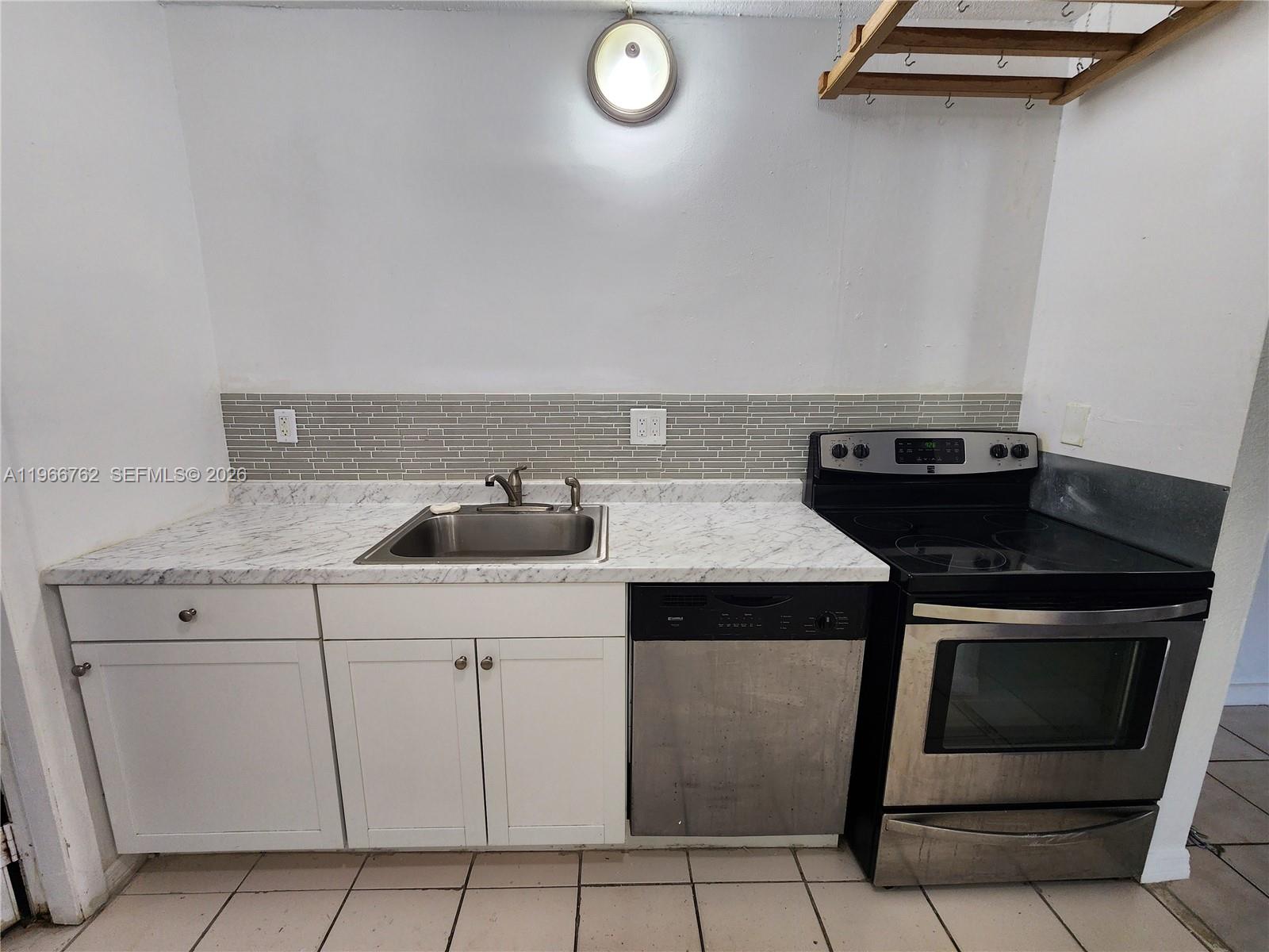 16311 Southwest 102nd Place, Unit A Miami, FL 33157 - Photo 3 of 15 a kitchen with a stove and a sink